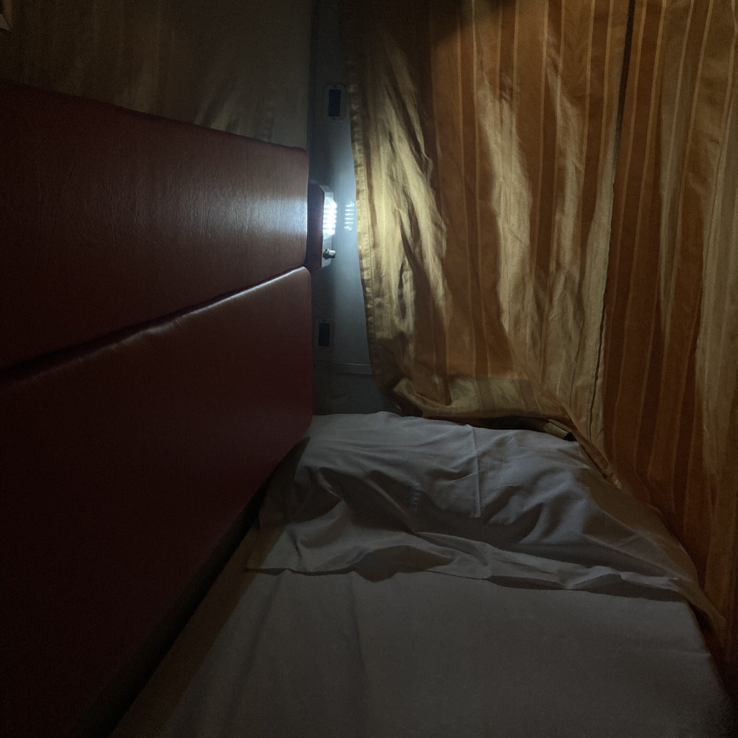 タイ国鉄の寝台列車の車内。ベッドと仕切りカーテンが並ぶ落ち着いた空間