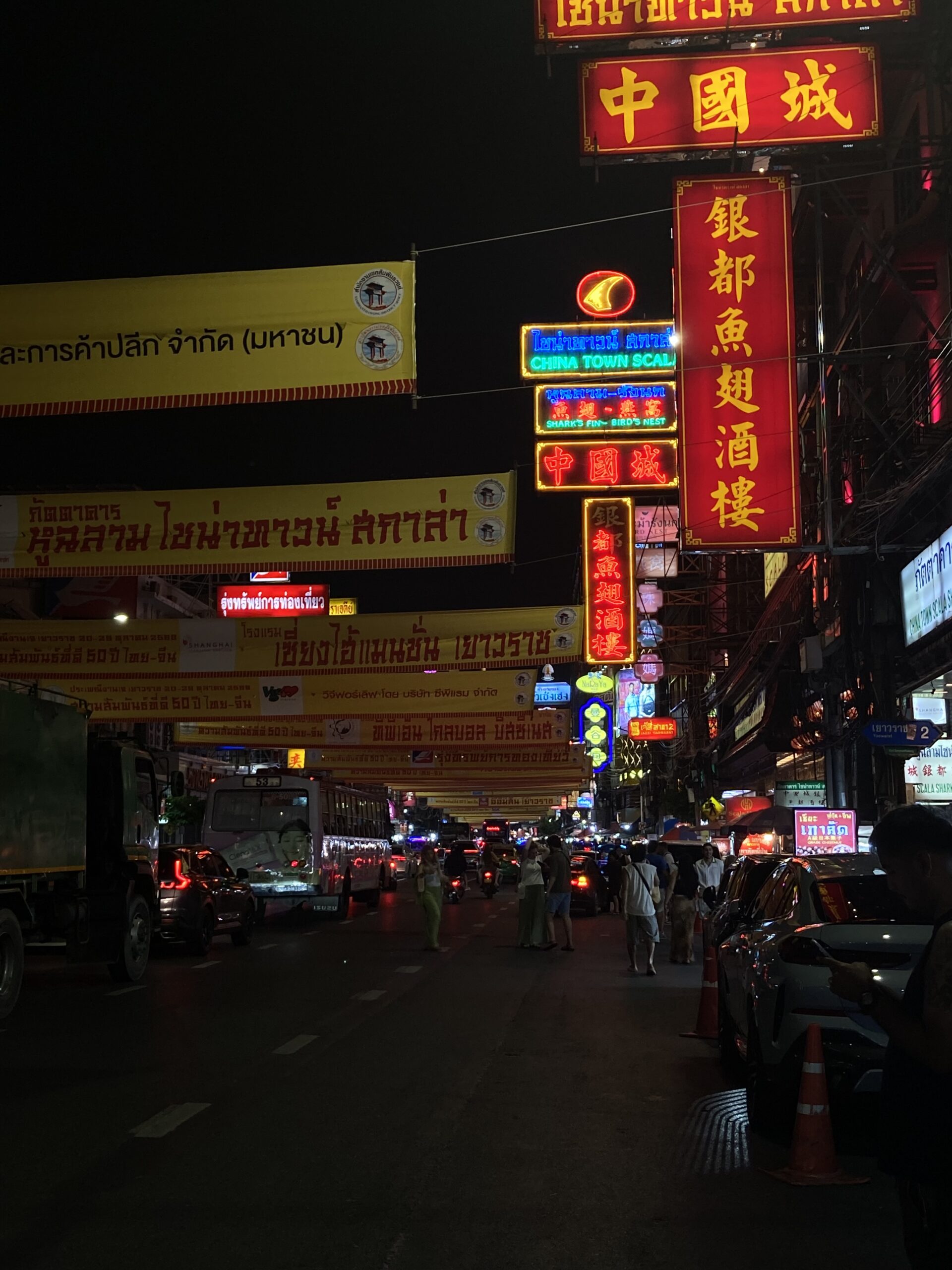 夜のヤワラート通りに連なる赤と金の中国語ネオン看板と行き交う人々
